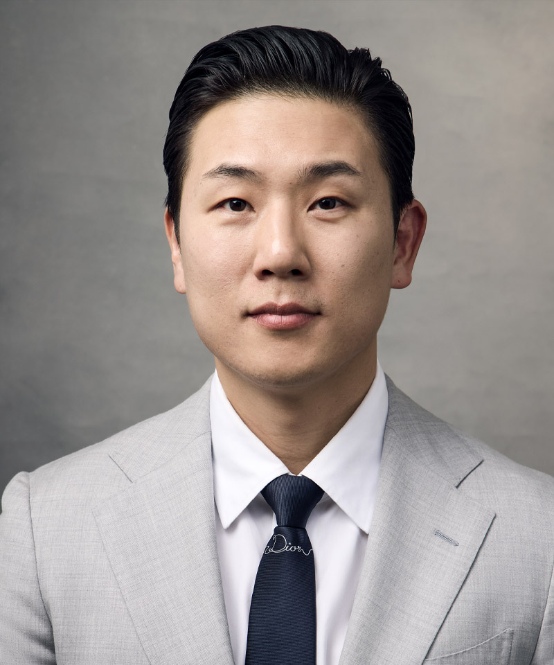 headshot of Dr. Gene K. Lee in gray suit at La Môem Plastic Surgery