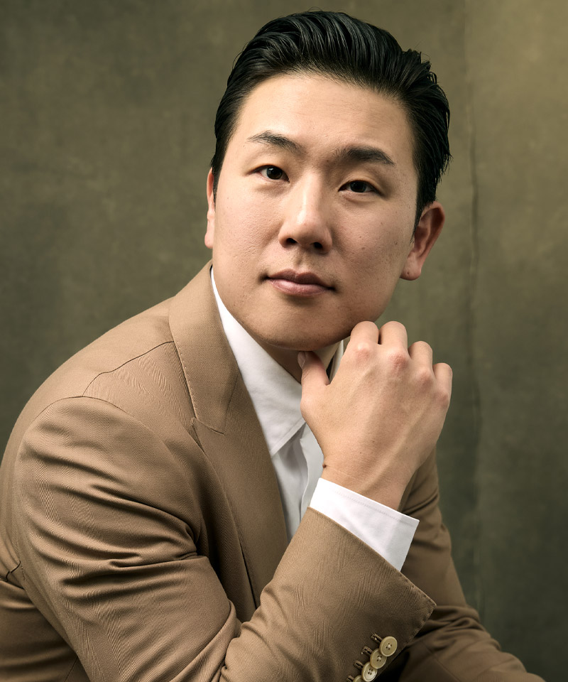 headshot of Dr. Gene K. Lee in brown suit at La Môem Plastic Surgery
